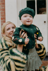 Shrimps baby & kids Darcy kilt. Green gingham wool skirt worn with Pomme & York knitted cardigan & Beret. AW26.